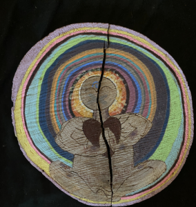 Drawing of a body at the center of multi-colored tree rings, black background.