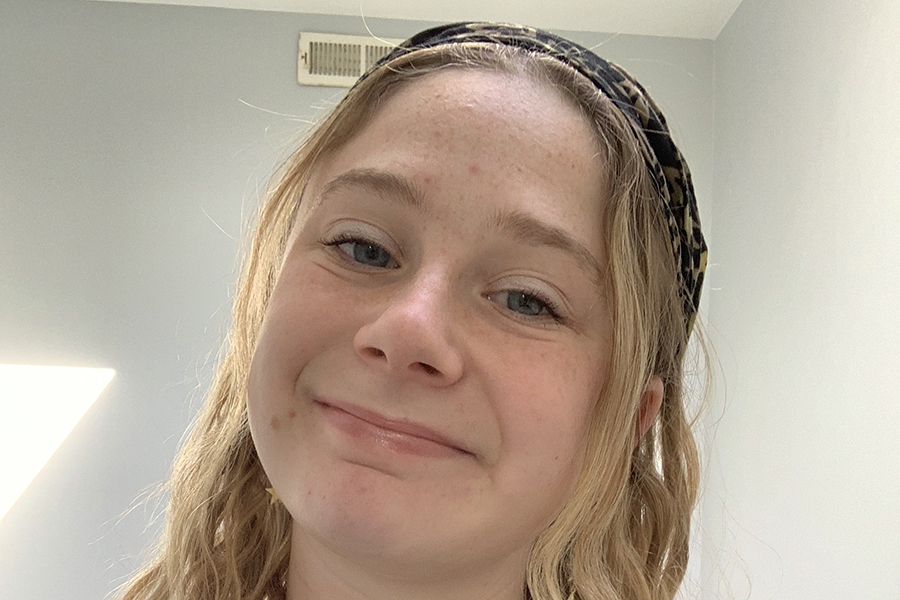Hannah Daniels has long blond hair and smiles in this close up photo.