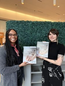 Image of Dr. Sara Chadwick and Dr. Morgan Jerald holding the book they co-authored titled "Psychology of Sexuality". 